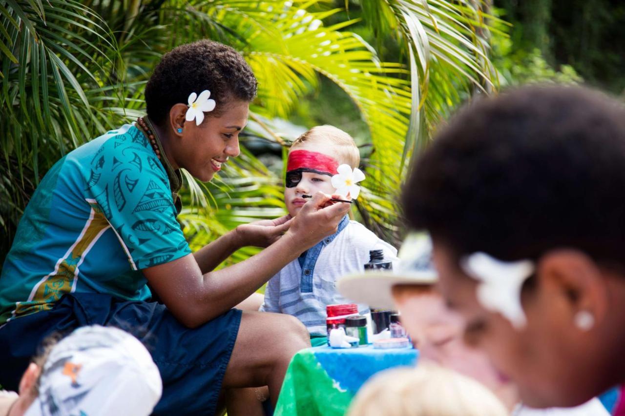 アウトリガー フィジー ビーチ リゾート コロトゴ エクステリア 写真 A young woman from the Cook Islands applying titi muka to a child's face